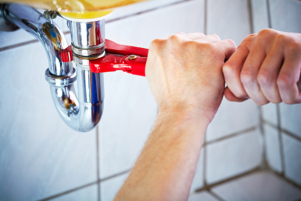fixing leaky sink with wrench